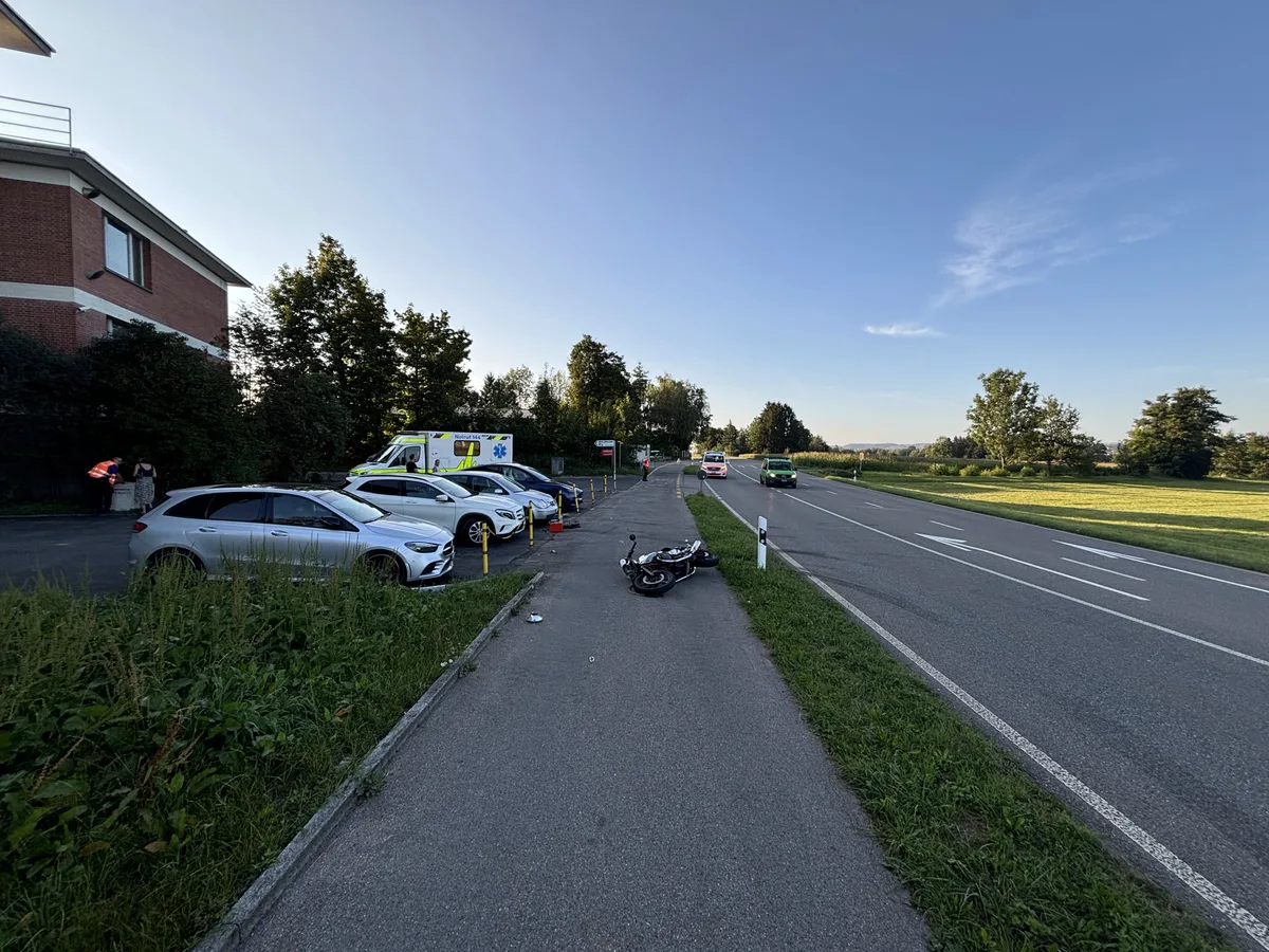 Das beschädigte Motorrad liegt am Strassenrand, während Rettungskräfte und Polizei vor Ort sind.